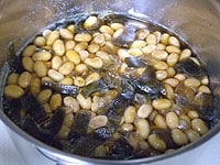 ゆでた大豆と1cm角に切った昆布、砂糖、醤油を入れます。大豆がひたひたに被るくらいまで水を加え蓋をします。<br />
圧力強にあわせ中火にかけます。圧力が強になったら弱火にして5分加熱して火を止めます。自然放置して圧力が抜けたら蓋を開けます。煮汁が多い時は、蓋を開けたまま煮詰めます。<br />
<br />