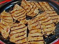 牛肉を焼き、サンチュ、白髪ねぎ、しょうがのせん切り、せり、韓国のりを盛りつけた皿に盛る。