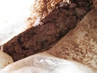 フィリングの入ったビニール袋に溶かしたチョコレートを加え、袋の上からよく揉み、チョコレートとフィリングをまんべんなく混ぜ合わせます。 すると、だんだんチョコレートの温度も低くなり、写真のようにまとまってきます。
