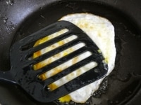 フライパンにサラダ油の半分の量を入れて火にかけます。卵を割り入れ、楊枝などで卵黄を軽く刺して穴をあけます。フタをして1分、白身に火が通ってきたらひっくり返し、フライ返しなどで押さえながら卵に完全に火を通します。