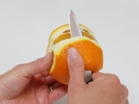 オレンジの上下を切り落とし、皮を薄皮ごとむく。<br />