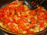 同じフライパンに残りのオリーブオイルを入れ、ニンニクを炒め、香りが出たら、玉ねぎも加えて炒めます。玉ねぎが透き通るまで炒めたら、トマトを加え、崩れるまで炒めます。