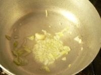 鍋にオリーブオイル、ニンニク、みじん切り玉ネギを入れて火にかけ、玉ネギがしんなりするまで炒める。