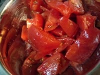 皮をむいたトマトは横半分に切り、包丁で種とゼリーをこそげとり、大きめにカットします。