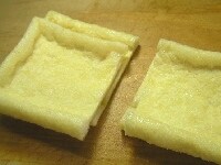 油揚げを半分に切り、手で袋状にあける。沸騰したお湯で1分ほど茹でて油抜きする