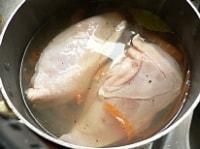 鶏肉は水で洗って水気をふく。鍋に水、白ワイン、スープの素、粗挽きブラックペッパー、くず野菜、ローリエを入れて火にかけ、煮立ったら鶏肉を入れ、再沸騰後6分ゆでて火を止め、ぴっちり蓋をして、そのまま1時間以上おく。<br />
