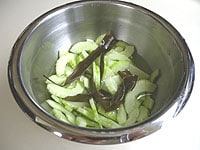 ボウルに塩、切れ目を入れた昆布、水を入れてよく混ぜ合わせます。薄切りにした白瓜を入れて40分ほど漬けておきます。