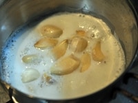 小鍋に牛乳（分量外）を入れ、皮をむいたにんにくを入れ、4～5回にわけて湯でこぼす。