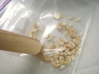 厚手のビニール袋などにカシューナッツを入れ、外側から麺棒などを使って砕きます。