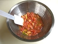 トマトは、皮をむきみじん切りにします。ボウルにトマト、柚子コショウ、残りの1/2個のレモンを絞り、混ぜ合わせてトマトソースをつくります。