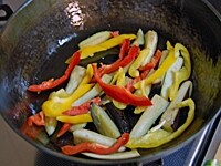 フライパンにごま油を入れて熱し、なす、塩を入れて炒める。焼き色がついたらパプリカを加え、しんなりするまで炒める。