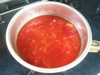トマト水煮缶と水を加え、一煮立ちさせます。