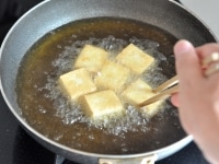 なすを取り出した後、豆腐の上下を裏返し、全体がこんがりきつね色になるまでじっくり揚げます。