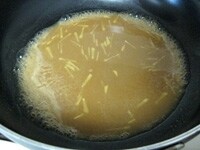 フライパンに生姜、味噌、はちみつ、酒、水を加え、中火で煮立たせます。