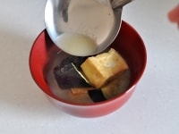 取り出したなすと豆腐は椀に盛り付けておき、鍋にだし600mlを沸かし、味噌大さじ3～4を溶き入れて味噌汁を作って上から注ぎます。仕上げに刻みねぎを散らして出来上がりです。