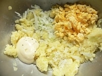 じゃがいもはよく洗って芽をくり抜き、ラップで包んでレンジで柔らかくなるまで加熱し、皮をむいてつぶす。玉ねぎはみじん切りにして布で包み、水でもみ洗いして絞る。卵は耐熱容器に入れ、レンジでこま切れに加熱しては混ぜを繰り返して煎り卵を作る。以上をあわせ、マヨネーズ、コショウ、塩、砂糖を加えて混ぜる。<br />