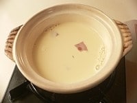 土鍋に豆乳と鶏肉を入れて蓋をして弱めの中火にかけ、煮立ってきたら麩を入れ、酒、塩、コショウで味をつける。