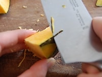 切ったかぼちゃの角に包丁を当て、削りとるようにして、面取りします。こうすることで、煮崩れしにくくなります。