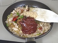 コチュジャン、味噌、お好みで種を取り除いた赤唐辛子を加え、炒めます。