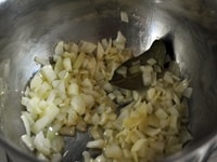 厚底鍋にオリーブオイル、ローリエとみじん切りにしたタマネギを入れ、中火にかけてよく炒める。