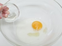 ボウルに卵・おろしにんにく・酢・塩・こしょうを加える。