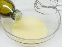 白っぽく泡立つまでよく混ぜオリーブ油を少しずつ加えてハンドミキサーで混ぜる。オイルが混ざったらまた少しオイルを加え、さらに混ぜる。これを繰り返し、オリーブ油・サラダ油を全部加える。