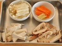 きのこは食べやすい大きさに切り、にんじんと生姜は皮をむいてせん切りにします。