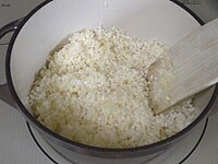 鍋にバターを入れて中火にかけます。たまねぎを加え炒めます。たまねぎが透き通ってきたら、米を加えしっかりと炒めます。<br />