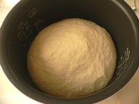 ラップを水で濡らしてかぶせ、30～35℃ぐらいの暖かい場所に置いて、1時間ほど発酵させる。1時間発酵させて、2.5倍ぐらいに膨らんだパン生地。<br />