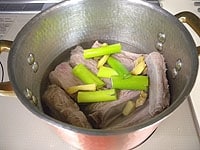 鍋に芋焼酎、水500ml、2のスペアリブ、生姜、ねぎを加え、中火弱で1時間ほど煮ます。あくが出てきたら取り除きます。