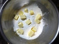&nbsp;薄力粉とグラニュー糖大さじ2を合わせてボウルにふるい入れます。冷やしておいたバターを2cm各に切り、加えます。