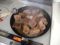肉の両面にしっかりと焦げ目が付いたら、ブランデーを加えて燃やします（フランベ）。フライパンから取り出し、煮込み用鍋に入れます。