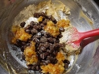 ふるった粉類を2～3回に分けて加え、全体をさっくりとゴムベラで混ぜます。さらに水気を切ったレーズン、オレンジピールを加え、よく混ぜます。