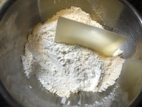 &nbsp;強力粉、ドライイースト、グラニュー糖、塩を合わせてふるいます。約2cm角にしたバターを加え、粉をまぶすようにカードで刻みます。バターが細かくなったら、指ですり混ぜます。