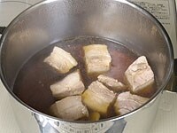 鍋に水、鶏がらスープの素、紹興酒、醤油、砂糖を入れて、中火にかけます。沸騰したら脂抜きした肉を加え、落とし蓋をして、弱火で30分ほど煮ます。