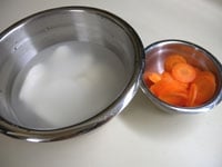 里芋は薄切りにして、水に放しておきます。にんじんは薄い輪切りにします。