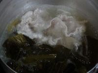 鍋に湯2カップを沸かし、豚肉を入れ、にんにくと高菜漬けを加える。5分間煮たら、ナンプラーで味をととのえる。<br />