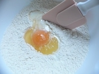 卵、オリーブオイル、牛乳、キルシュ、バニラエッセンス、みじん切りにしたレモンの皮を加える。<br />
