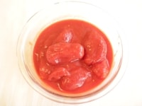 ホール缶のトマトをフライパンに入れます。<br />
<br />
この時、ヘラでトマトをつぶすようにしながら炒めます。