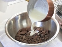 ボウルにチョコレートを入れ、沸騰した生クリームを入れて木べらで丁寧に混ぜて溶かします。