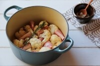 厚手の鍋にカリフラワー、ベーコンを並べ、水、白ワインビネガー、オリーブオイル、塩を回しかける。ローズマリーをのせてふたをし、約10分蒸す。
