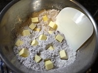 約2cm角にカットしたバターを粉類に加え、カードで米粒大になるまで刻みます。