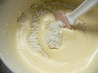 粉を広げて加え、ゴムベラで底からすくうようにさっくりと混ぜる。<br />