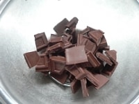 チョコレートを小さく割る。耐熱容器に生クリームを入れて電子レンジで沸騰させ、チョコレートの上に注ぐ。<br />