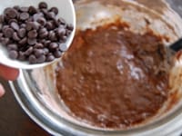 粉類を2回に分けて加え、ゴムベラで粉っぽさがなくなるまで混ぜ合わせます。<br />
<br />
チョコチップを加え、全体に混ぜます。<br />