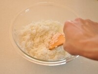 熱々のご飯をボウルに入れ、米酢、砂糖、塩をしっかりと混ぜ溶かして作った寿司酢を全体にまわしかけます。寿司酢がいきわたるように、しゃもじを立てて切るように混ぜ合わせます。<br />