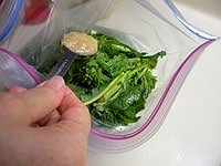 密封袋に菜の花と塩麹を入れ、手でよく揉みます。