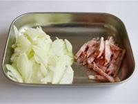 鍋にお湯を沸かし、ショートパスタを表示通りに茹でます。玉ねぎを薄切りに、ベーコンを5ｍｍ程度の幅に切ります。<br />