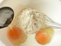 ボウルにホットケーキミックスを入れ、卵、牛乳、はちみつを入れて泡だて器でグルグル混ぜる。<br />