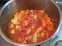 セロリ、人参を入れて炒め、じゃがいも、トマトを加える。トマトが崩れたら、トマト水煮缶を入れて軽く火を通す。スープストック、ローリエを入れ、アクをとりながら材料に火が通るまで煮る。